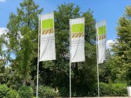 Flaggen BaySG vor grünen Bäumen