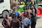 Diskussionsrunde mit 5 Männern vor einem grünen Traktor