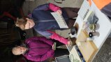 2 Frauen stehen vor einem Tisch mit viele Utensilien und erklären