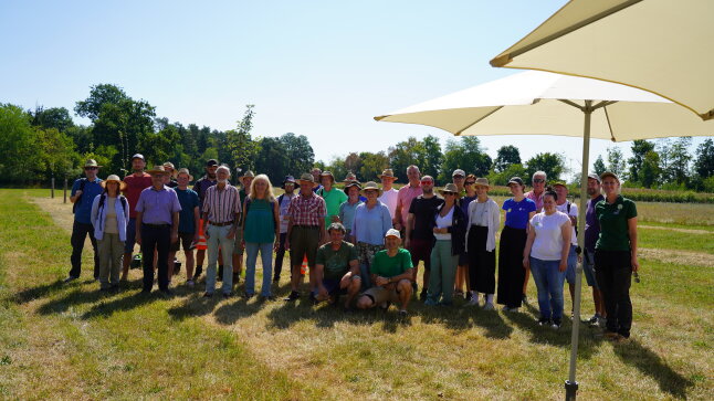 Veranstaltungsgäste stehen zu einem Gruppenfoto zusammen